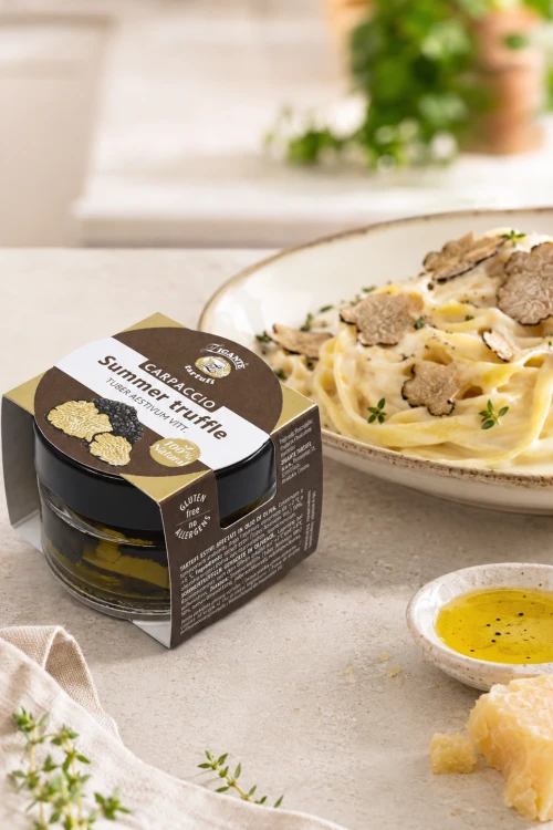Słoiczek Zigante z czarną letnią truflą siekaną obok makaronu tagliatelle