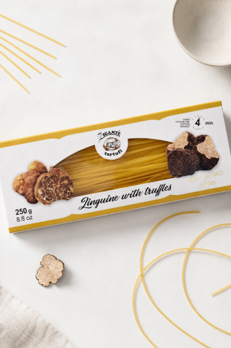 Opakowanie Zigante Linguine z truflami 250 g obok suchego makaronu na jasnym blacie