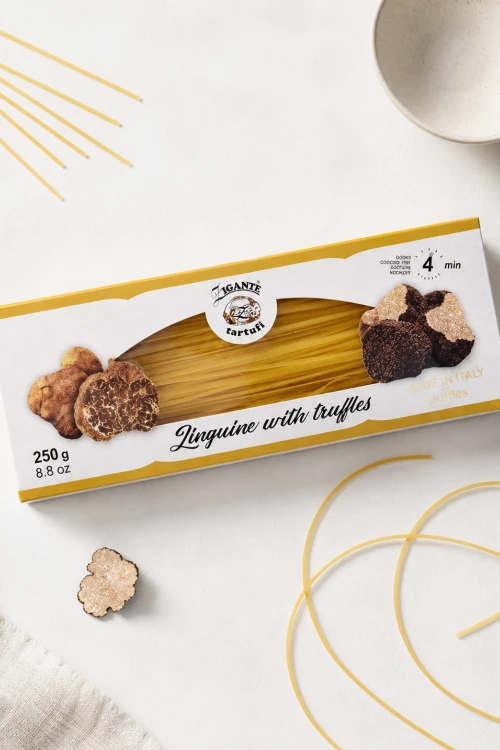 Opakowanie Zigante Linguine z truflami 250 g obok suchego makaronu na jasnym blacie