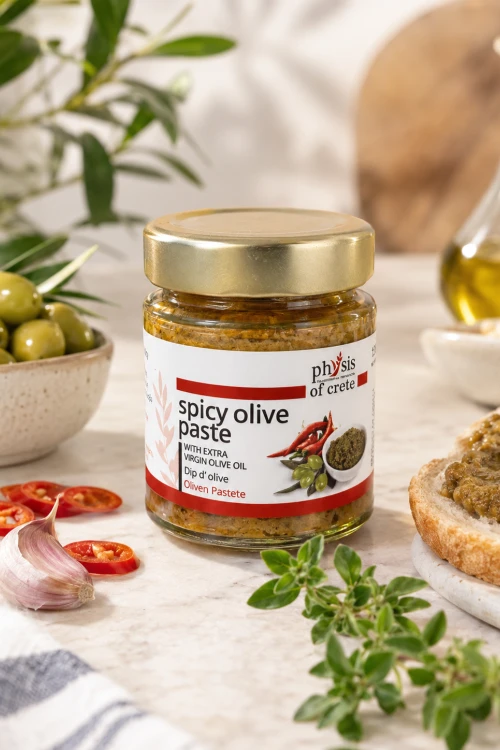Pikantna pasta z zielonych oliwek Physis z chili i suszonymi pomidorami obok słoika